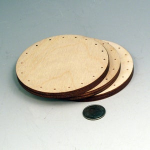 May include: Three round wooden discs with holes around the edge. The discs are stacked on top of each other.