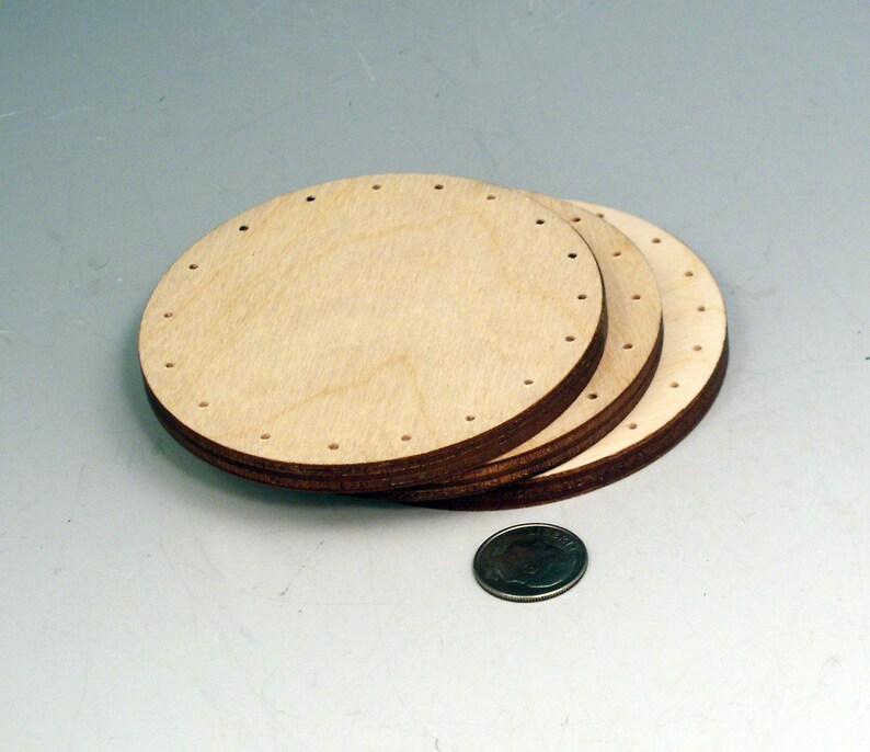 May include: Three round wooden discs with holes around the edge. The discs are stacked on top of each other.