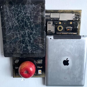 Könnte beinhalten: Eine Collage aus drei Apple-Geräten: ein zerbrochenes iPad, eine Platine und ein neueres iPad mit dem Apple-Logo und dem Wort "iPad" auf der Rückseite. Ein roter Apfel liegt auf der Platine.