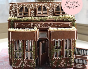 May include: A gingerbread bookshop structure featuring brown walls with white icing details, green icing vines, and a sign reading BOOKSHOP. A small gingerbread stack of books labeled Sale sits to the right. A pink circle includes the text Recipes Included!