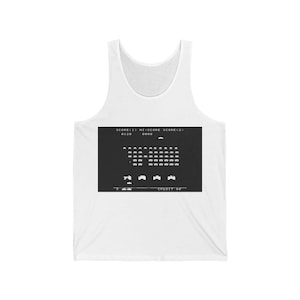 Könnte beinhalten: Weißes Tanktop mit einer schwarz-weißen Grafik eines Vintage-Videospielbildschirms. Der Bildschirm zeigt den Text "SCORE<1> HI-SCORE SCORE<2> 0120 0000 CREDIT 00" und ein Spiel Space Invaders.