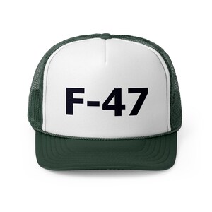 Peut inclure: Un chapeau de camionneur blanc avec un filet vert à l'arrière. Le devant du chapeau porte un texte noir qui dit "F-47".