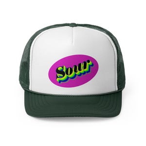 May include: A dark green and white trucker hat with the word "Sour" in a colorful, 3D design on the front. The word is inside a pink oval. The hat has a mesh back and a curved brim.