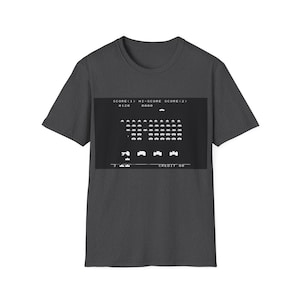 Könnte beinhalten: Ein dunkel-helles graues T-Shirt mit einer Retro-Videospielgrafik von Space Invaders. Die Grafik zeigt den Spielbildschirm mit dem Punktestand, dem Highscore und der Anzahl der verbleibenden Credits. Der Text auf dem Bildschirm lautet "SCORE<1> HI-SCORE SCORE<2> 0120 0000 CREDIT 00".