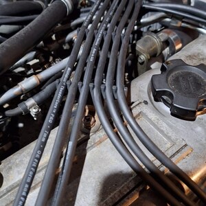 May include: Close-up of a car engine with black spark plug wires. The wires are labelled "Thundercore Pro" and "7mm - OE Fit Form and Function".