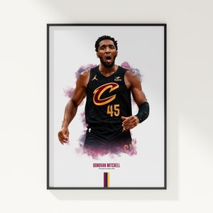 May include: Framed print of Donovan Mitchell in a Cleveland Cavaliers basketball uniform. The black jersey has the number 45 and a large "C" logo. The image has a watercolour effect with purple and red splashes.