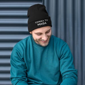 May include: A black beanie with the text "CHINGA TU MAGA" in white lettering.