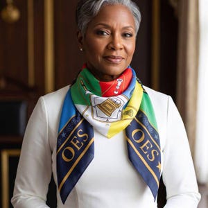 May include: A square silk scarf featuring a vibrant multi-colored design with green, blue, red, and yellow sections. The scarf displays the letters OES in gold, along with various symbolic icons including a book, a gavel, and stars on a dark blue border.