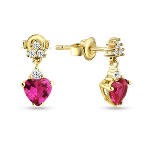 Może przedstawiać: Para złotych kolczyków z różową, w kształcie serca, błyszczącą kamieniem szlachetnym. Każdy kolczyk ma małą grupę białych kamieni szlachetnych na górze i pojedynczy biały kamień szlachetny nad kamieniem w kształcie serca.
