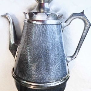May include: A silver and black vintage coffee pot with a textured surface and a decorative lid.