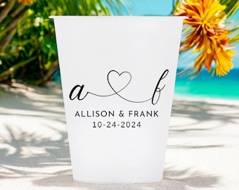 May include: White plastic cup with a black design of the letters "a" and "b" connected by a heart. The text "Allison & Frank 10-24-2024" is printed below the design.