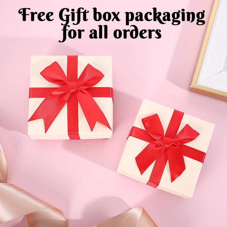 May include: Two white gift boxes with red ribbon bows. The boxes are on a pink background. The text "Free Gift box packaging for all orders" is at the top of the image.