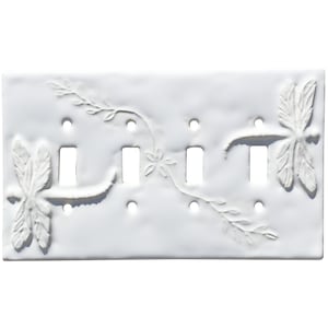May include: White ceramic light switch cover featuring a decorative dragonfly and floral design.