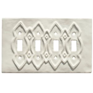 May include: White ceramic light switch plate with an intricate, embossed, geometric design. The plate has three toggle switches.