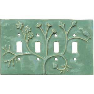 以下が含まれることがあります： ターコイズ色のセラミック製ライトスイッチプレート。花と鳥の木のレリーフデザイン。プレートには4つのスイッチ開口部があり、光沢のある仕上がりです。