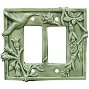May include: A green ceramic double light switch cover with a hummingbird, flowers, and leaves.