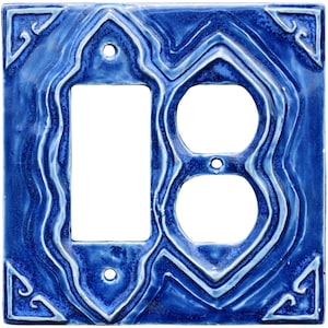 以下が含まれることがあります： 青いセラミック製のライトスイッチとコンセントカバー。装飾的な渦巻き模様のデザイン。カバーには、シングルライトスイッチと2つのコンセント用の開口部があります。コーナーには様式化されたスクロールデザインが施されています。