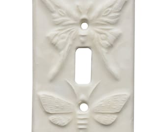 HECHO A MEDIDA: Tapa de interruptor de luz de cerámica con diseño de polillas, acabado en esmalte color blanco hueso.