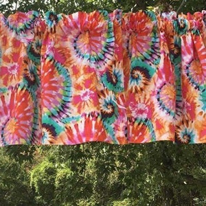 K&ouml;nnte beinhalten: Eine bunte Binde mit einem wirbelnden Muster in den Farben Pink, Orange, T&uuml;rkis und Wei&szlig;.