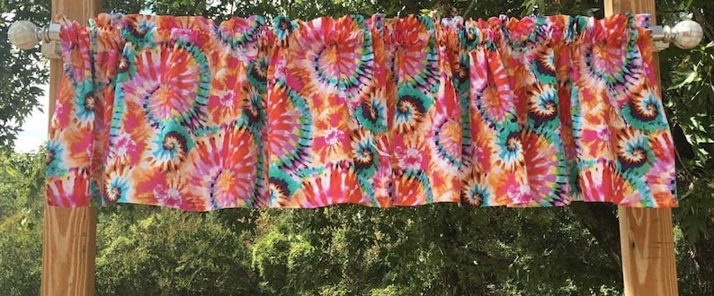 K&ouml;nnte beinhalten: Eine bunte Binde mit einem wirbelnden Muster in den Farben Pink, Orange, T&uuml;rkis und Wei&szlig;.