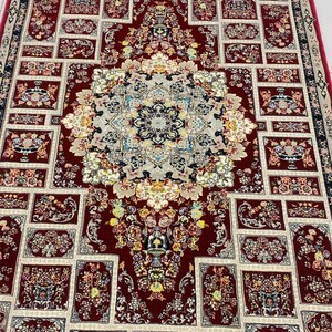 May include: A detailed, rectangular rug with a central medallion and repeating floral patterns. The rug features a deep red background with cream and blue accents. The design includes intricate floral and geometric elements, creating a classic, ornate look.