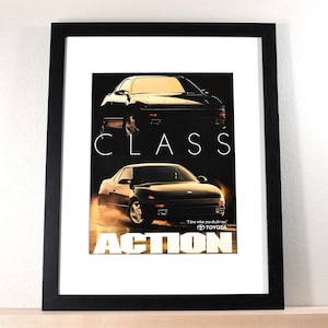 May include: A white ceramic mug with a black handle and the text "But First, Coffee" in a bold, black font. The mug is set against a blurred background, suggesting a cozy setting.