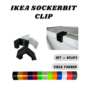 Op de afbeelding: De afbeelding toont IKEA SOCKERBIT CLIP clips in zwart en wit, met een set kleurrijke clips onderaan. De tekst "SET = 4CLIPS" en "VIELE FARBEN" is ook zichtbaar.