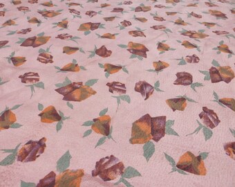 Pode incluir: Um tecido rosa com um padrão repetido de rosas marrons e laranja. As rosas são estilizadas e têm um design geométrico.