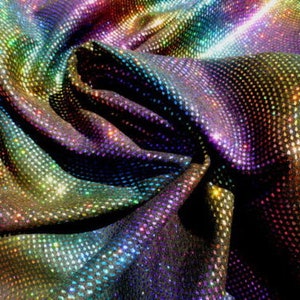 May include: Close-up of iridescent fabric with a rainbow pattern. The fabric has a textured, glittery surface.