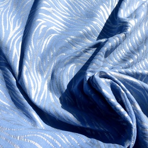 Op de afbeelding: Blauwe stof met een zilveren metallic zebraprint.