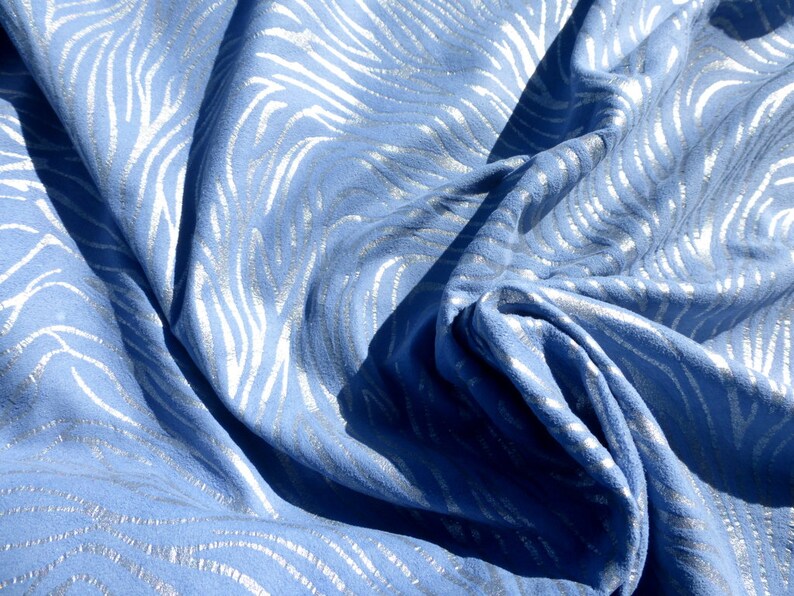Op de afbeelding: Blauwe stof met een zilveren metallic zebraprint.