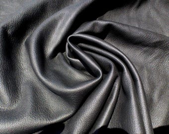 Couro de cordeiro preto intenso, macio, com textura granulada e leve.