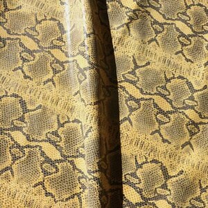 Peut inclure: Gros plan sur un motif de peau de serpent jaune et noir. Le motif est composé de petites écailles qui se chevauchent.