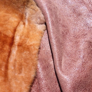 May include: Close-up of two different types of fabric. One side is a soft, brown fur, and the other side is a smooth, pink leather.