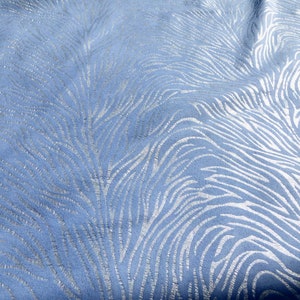 Op de afbeelding: Een close-up van een blauwe stof met een zilveren zebraprint.