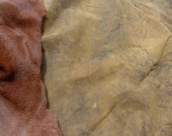 Może przedstawiać: Zbliżenie dwóch teksturowanych tkanin. Jedna to głębokie, czerwonobrązowe sztuczne futro, a druga to stonowany oliwkowozielony materiał z ciemniejszymi, niebiesko-szarymi plamami. Tkaniny leżą obok siebie, futro po lewej stronie.