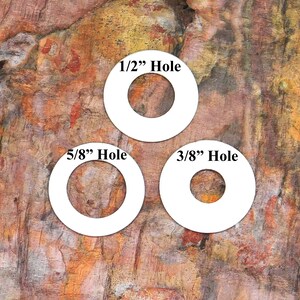 Pu&ograve; includere: Tre cerchi di plastica bianca con fori di diverse dimensioni. I cerchi sono etichettati "1/2" Hole", "5/8" Hole" e "3/8" Hole".