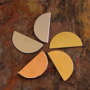 May include: Five metal half-circle shapes in different colors. The shapes are arranged in a flower pattern. The colors are silver, gold, copper, and two shades of gold.