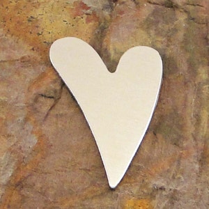 May include: A plain white metal heart shape, with a slightly rounded point at the bottom.