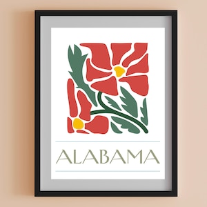 May include: Framed art print with a floral design in red, green, and yellow. The word "ALABAMA" is printed below the illustration. The print is on a white background and framed in black. A decorative piece for the home.