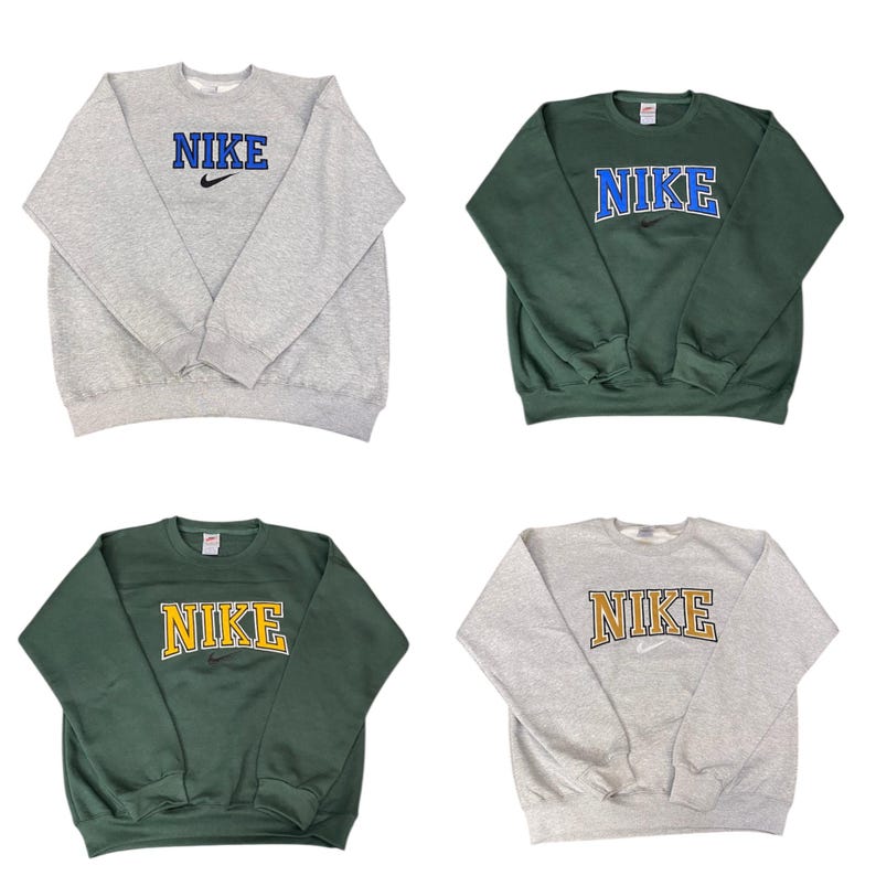 Pu&ograve; includere: Quattro felpe girocollo Nike. Due sono grigie, una con scritta "NIKE" blu e una dorata. Le altre due sono verdi, una con scritta "NIKE" blu e una dorata. Tutte presentano il logo Nike.