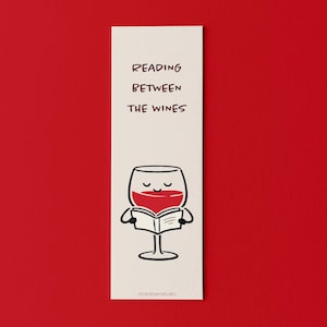 Pode incluir: Um marcador de página creme com um desenho de um copo de vinho de desenho animado lendo um livro, cheio de líquido vermelho. O texto "READING BETWEEN THE WINES" está escrito em preto. O fundo é vermelho vivo.