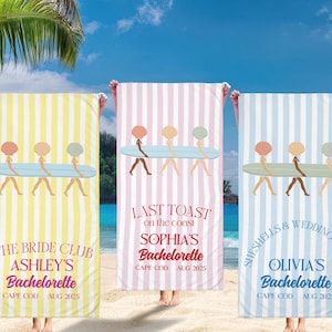 May include: Three striped beach towels in yellow, pink, and blue. Each towel displays a seashell design carrying a surfboard, with text indicating a bachelorette party in Cape Cod, August 2025.