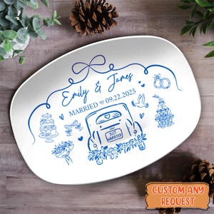 May include: White ceramic serving platter with a blue wedding design. The platter features the names "Emily & James", the date 09.22.2025, and illustrations of a car, cake, champagne glasses, and rings. The words "Just Married" are also visible.