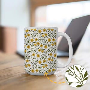 May include: White ceramic mug with a floral pattern of yellow flowers and green leaves. The mug has a white handle and the words "Fuck Trump" are printed on the bottom of the mug.