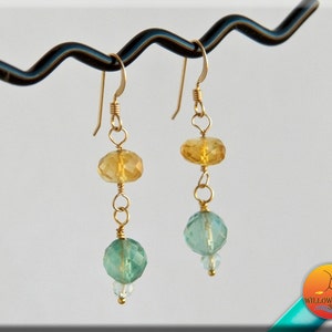 May include: Gold earrings with faceted yellow and green gemstone beads.