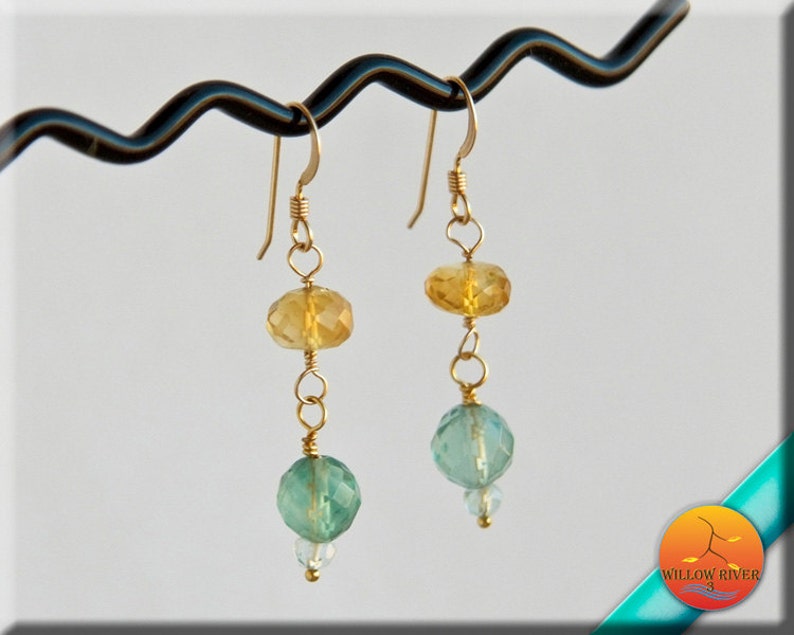 May include: Gold earrings with faceted yellow and green gemstone beads.
