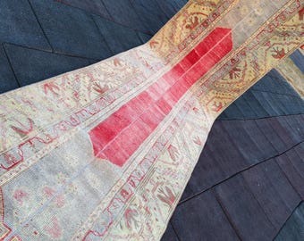 May include: A vintage runner rug with a cream background and a red stripe down the center. The rug has a geometric pattern with floral motifs in shades of cream, red, and brown.