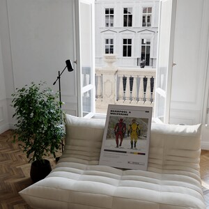 K&ouml;nnte beinhalten: Ein wei&szlig;es Sofa mit einem Poster darauf, auf dem "Deadpool & Wolverine" steht. Das Poster zeigt einen roten und schwarzen Deadpool und einen gelben Wolverine. Das Sofa steht in einem Raum mit einem Fenster, das auf einen Balkon blickt.