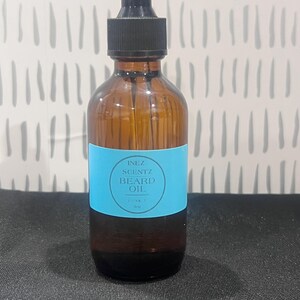 May include: A brown glass bottle with a black dropper top and a blue label that reads "INEZ SCENTZ BEARD OIL 1 oz 30 ml".